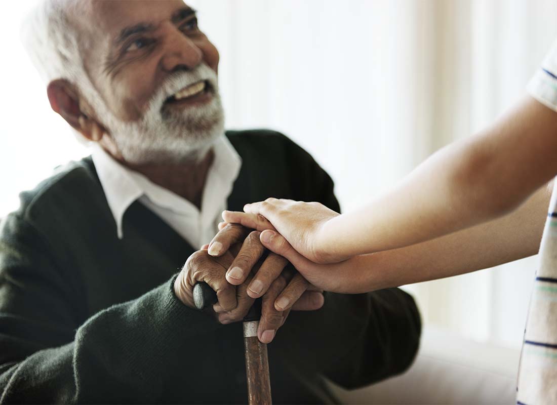 Long-Term Care Insurance - Senior Man Close-up While Sitting and Talking with His Relative during a Visit to His Residence at a Senior Care Facility