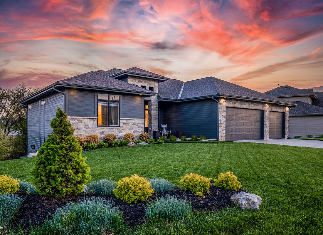 Homeowners Insurance - Luxury Home During Twilight Golden Hour With Pink and Purple Sky and Lush Landscaping in Nebraska USA