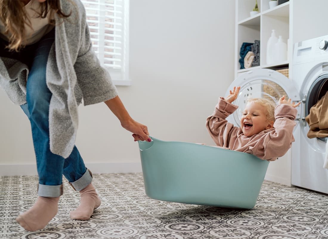 Life Insurance - Mother Pulling Her Child in a Bucket in the Laundry Room