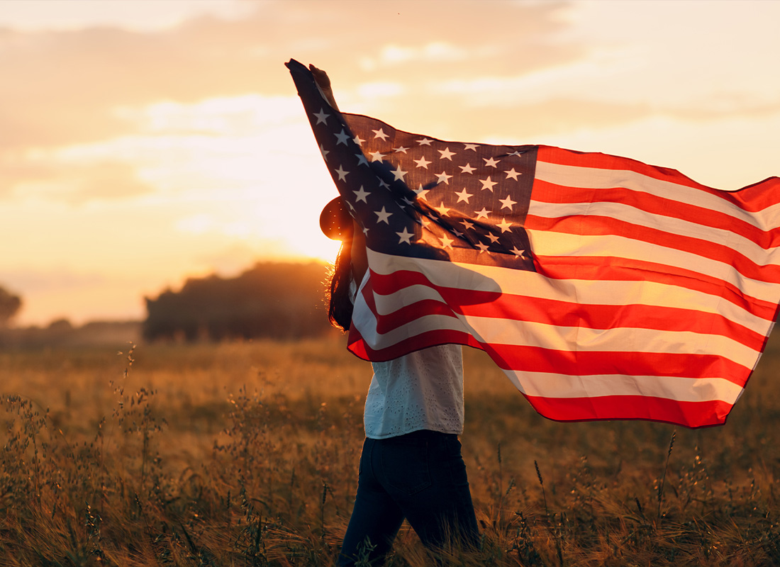 We are Independent - Female Farmer in Wheat Field Waving American Flag During Sunset